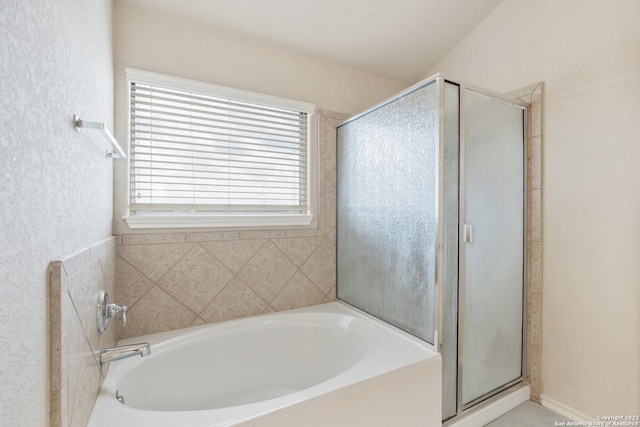 bathroom featuring shower with separate bathtub