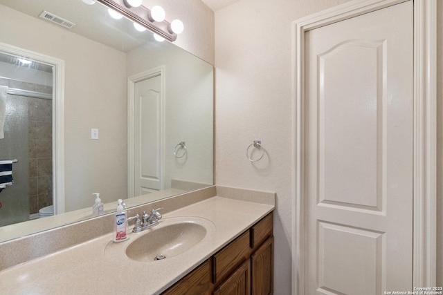 bathroom featuring vanity, toilet, and walk in shower