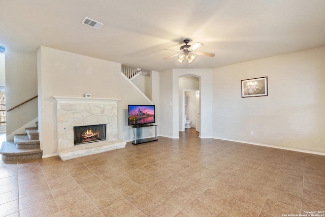 unfurnished living room with a fireplace and ceiling fan