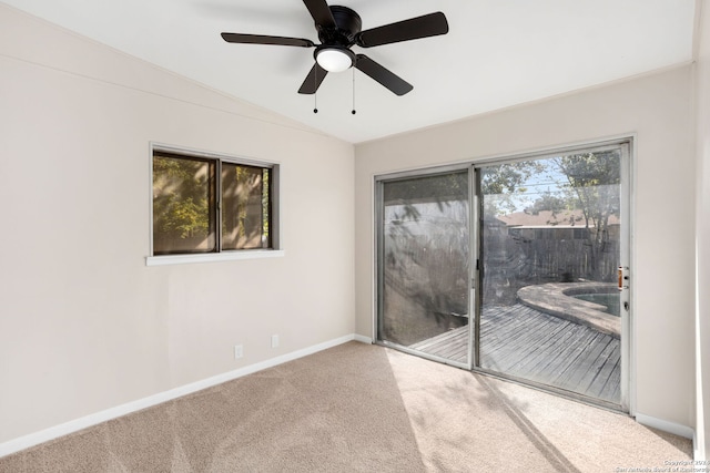 empty room with carpet flooring, vaulted ceiling, and ceiling fan