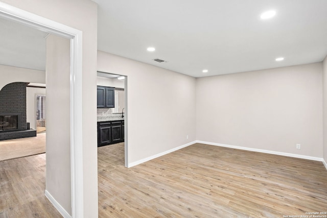 unfurnished room featuring light hardwood / wood-style floors and a fireplace