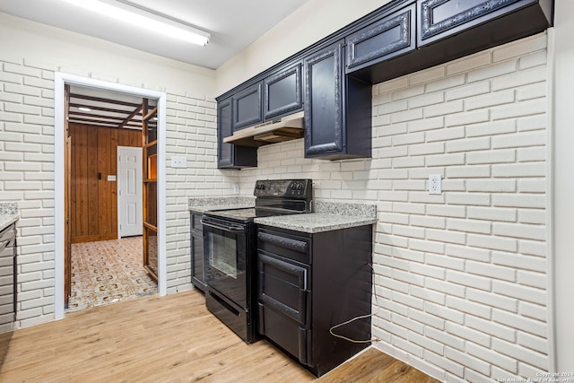 kitchen featuring light stone countertops, electric range, and light hardwood / wood-style floors