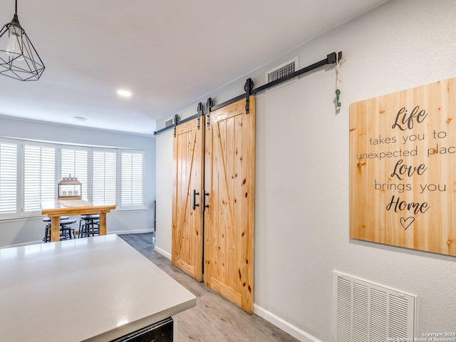 interior space featuring a barn door and light hardwood / wood-style floors