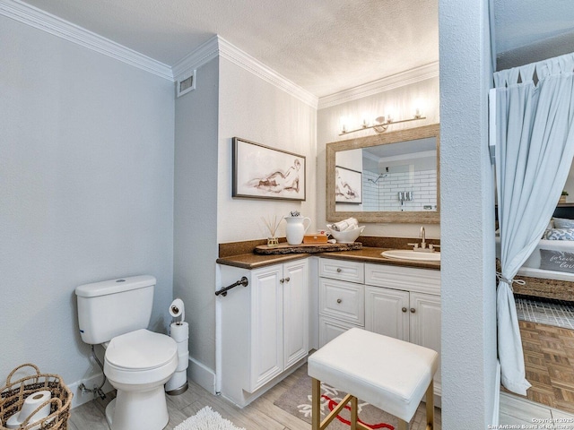 bathroom with ornamental molding, vanity, a textured ceiling, a shower, and toilet