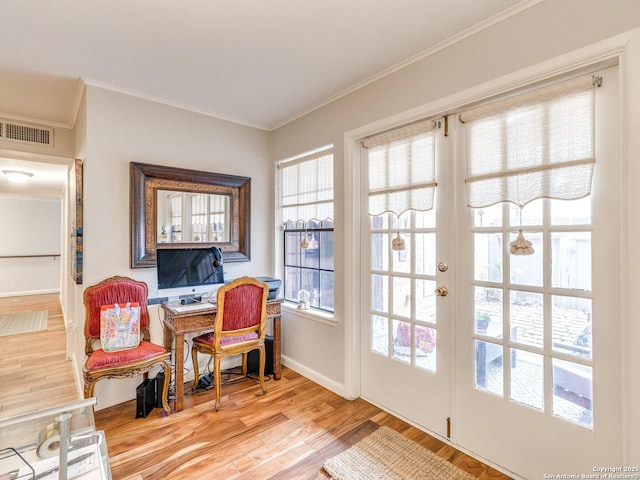 interior space featuring crown molding, french doors, and light wood-type flooring