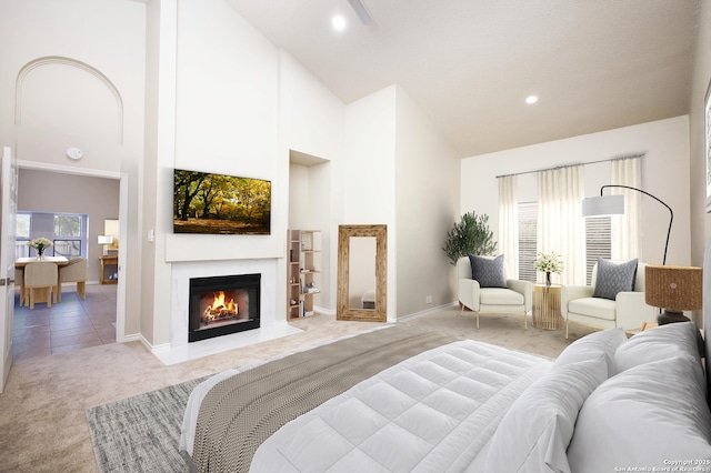 bedroom featuring light colored carpet and high vaulted ceiling