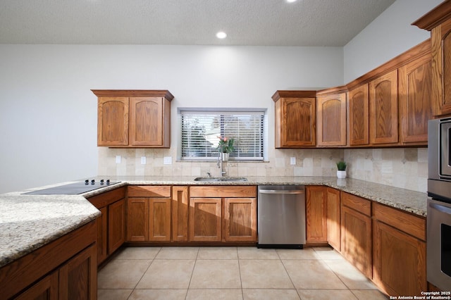 kitchen featuring light tile patterned floors, light stone counters, stainless steel dishwasher, and sink