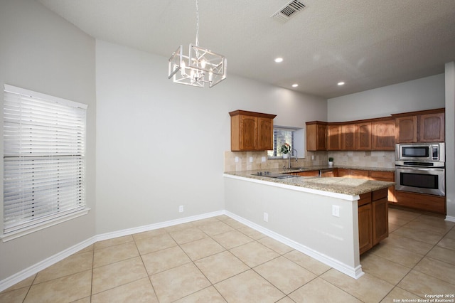 kitchen with kitchen peninsula, tasteful backsplash, stainless steel appliances, light tile patterned floors, and pendant lighting