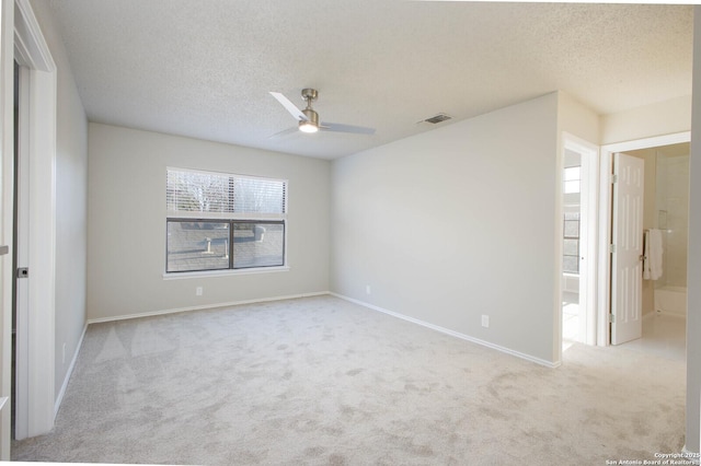 unfurnished bedroom with ensuite bath, ceiling fan, light carpet, and a textured ceiling