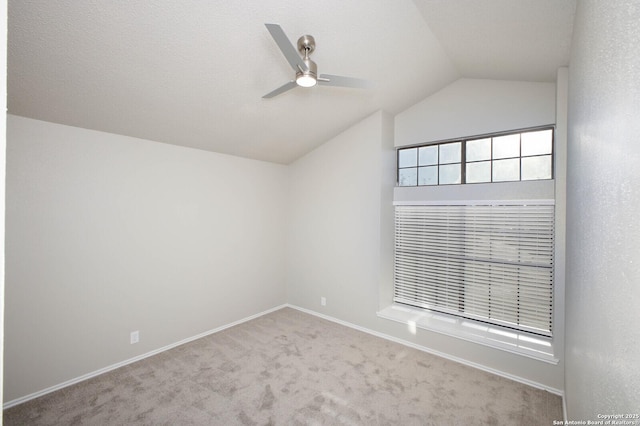 empty room with ceiling fan, lofted ceiling, and light carpet