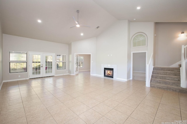 unfurnished living room with french doors, high vaulted ceiling, ceiling fan, and light tile patterned flooring