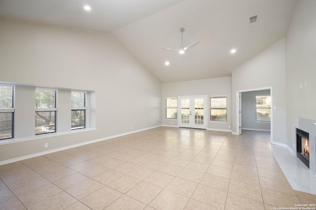 unfurnished living room with light tile patterned floors, french doors, high vaulted ceiling, and ceiling fan