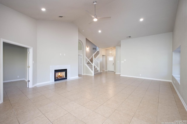 unfurnished living room with light tile patterned floors, high vaulted ceiling, and ceiling fan