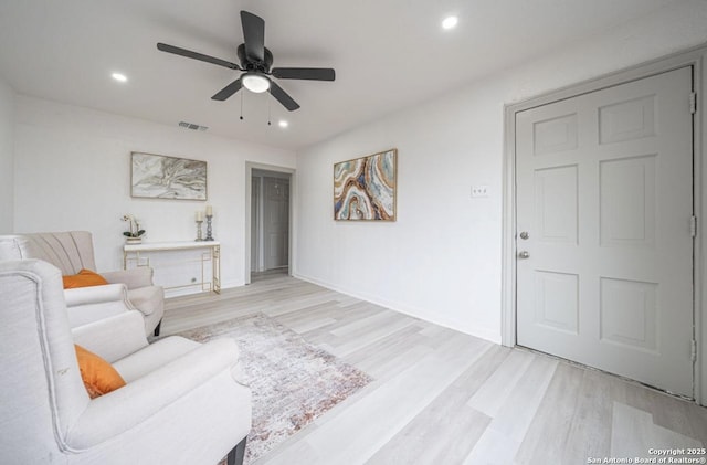 living room with ceiling fan and light hardwood / wood-style floors