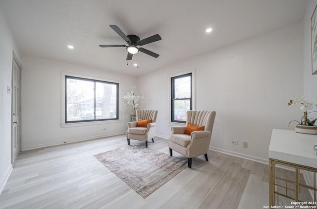 living area featuring light hardwood / wood-style floors, plenty of natural light, and ceiling fan