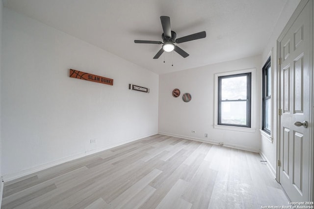 empty room with ceiling fan and light hardwood / wood-style floors