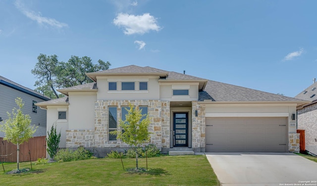 prairie-style home featuring a garage and a front yard