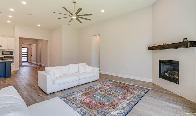 living room featuring ceiling fan and light hardwood / wood-style flooring