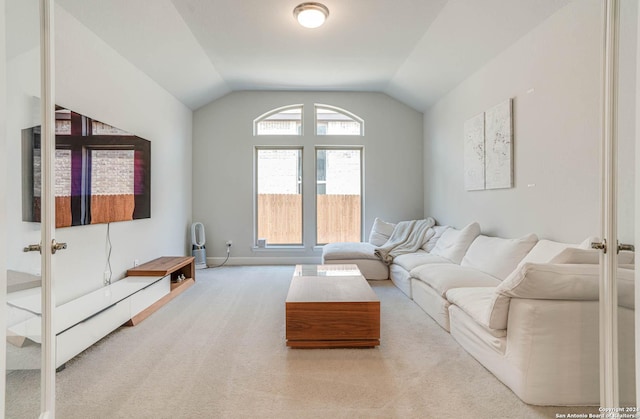 carpeted living room with french doors and vaulted ceiling