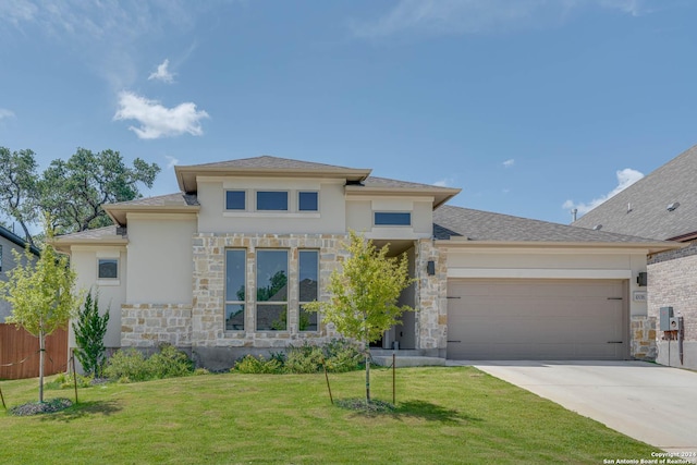 prairie-style house featuring a front lawn and a garage