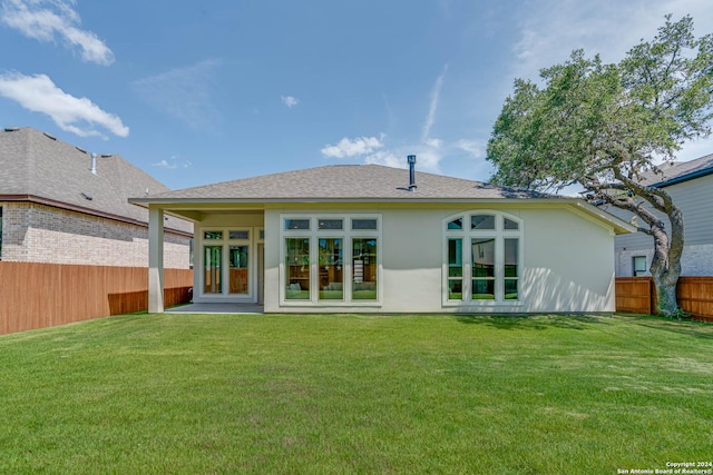 back of house featuring a lawn