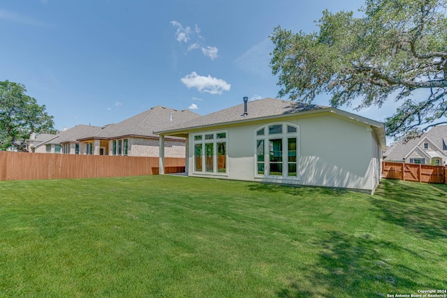 back of house featuring a lawn