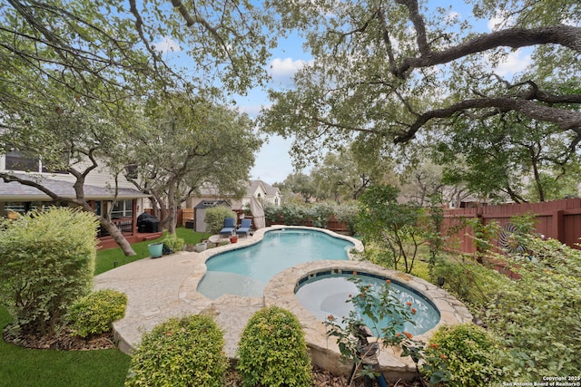 view of swimming pool with an in ground hot tub