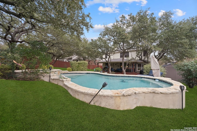 view of swimming pool with a yard