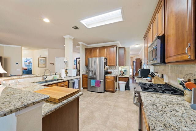 kitchen with sink, stainless steel appliances, tasteful backsplash, light stone counters, and ornamental molding