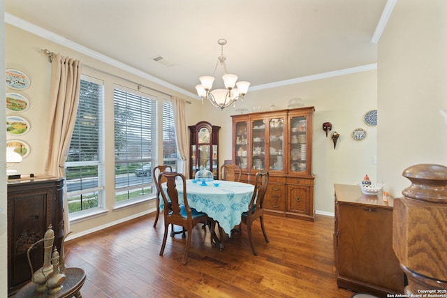 dining area with a chandelier, dark hardwood / wood-style flooring, and crown molding