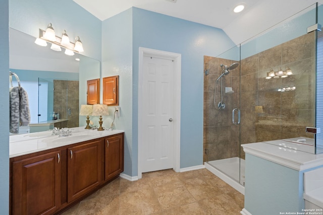 bathroom with vanity, a shower with shower door, and lofted ceiling