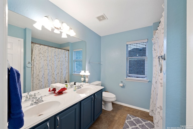 bathroom with a chandelier, vanity, and toilet