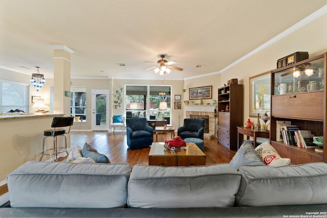 living room with hardwood / wood-style flooring, ceiling fan, and crown molding