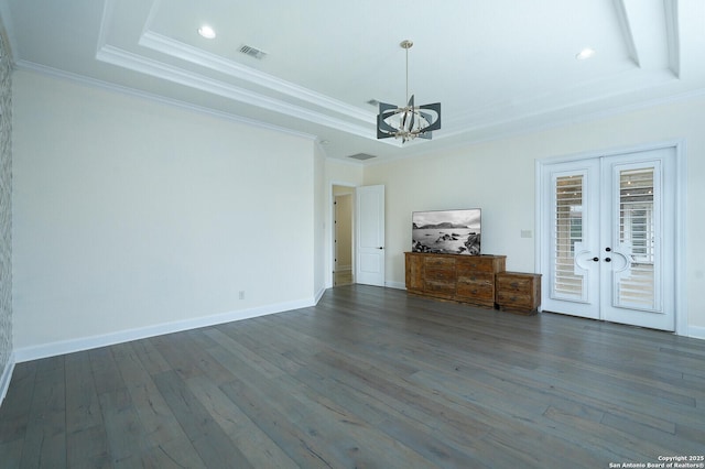 interior space with a tray ceiling, crown molding, french doors, and a chandelier