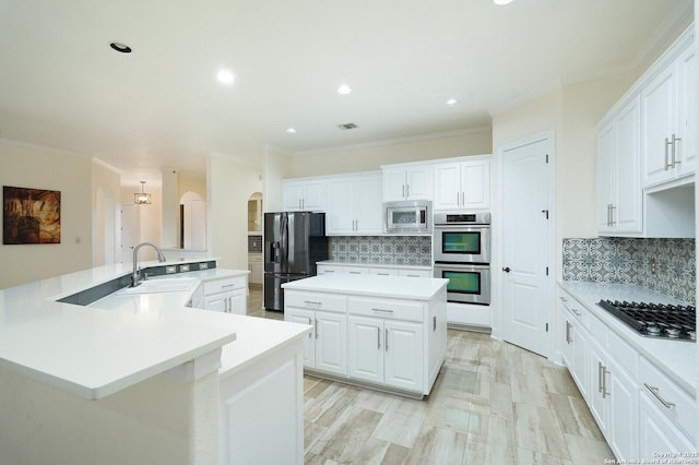 kitchen with white cabinets, a spacious island, backsplash, and appliances with stainless steel finishes