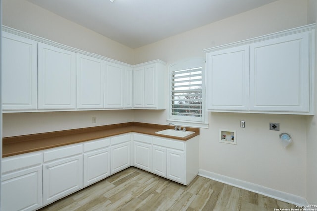 laundry area featuring sink, cabinets, hookup for an electric dryer, hookup for a washing machine, and light wood-type flooring