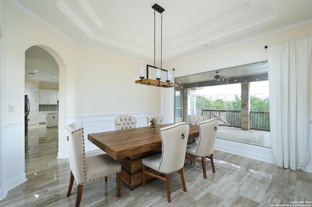 dining space featuring a tray ceiling, ceiling fan, and ornamental molding