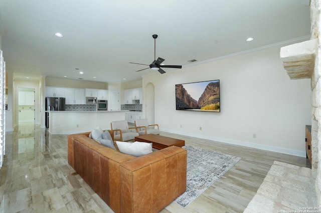 living room featuring ceiling fan, crown molding, and light hardwood / wood-style floors