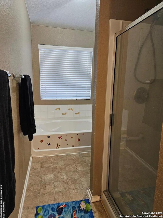 bathroom with plus walk in shower and a textured ceiling