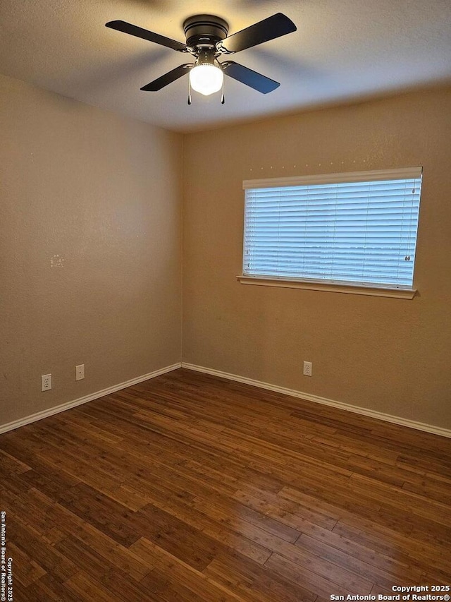 spare room featuring ceiling fan and dark hardwood / wood-style flooring