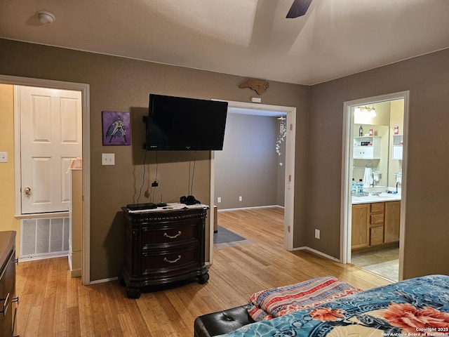 bedroom featuring connected bathroom, ceiling fan, light hardwood / wood-style flooring, and sink