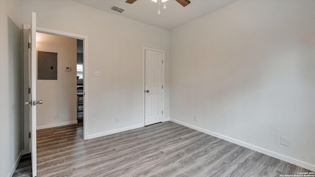 unfurnished bedroom featuring electric panel, ceiling fan, and light hardwood / wood-style floors