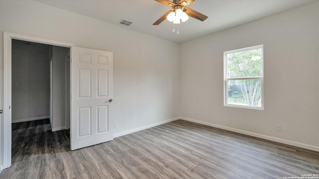 unfurnished room with ceiling fan and wood-type flooring