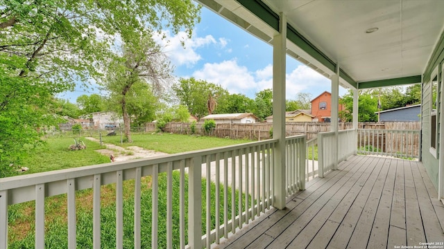 wooden terrace featuring a lawn