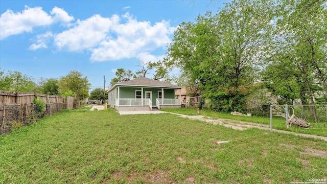 rear view of house with a lawn and covered porch