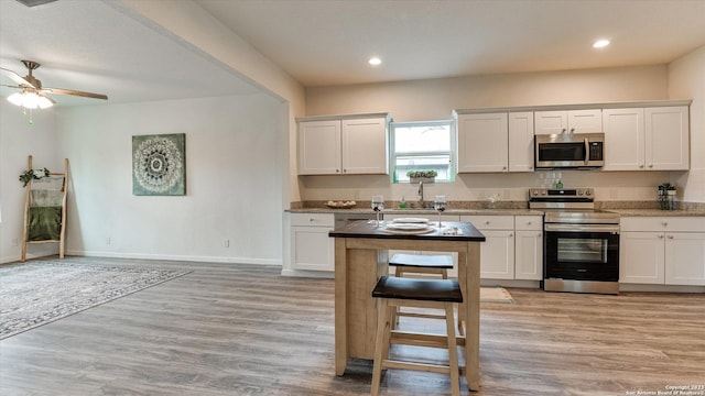 kitchen featuring sink, white cabinets, stainless steel appliances, and light hardwood / wood-style floors