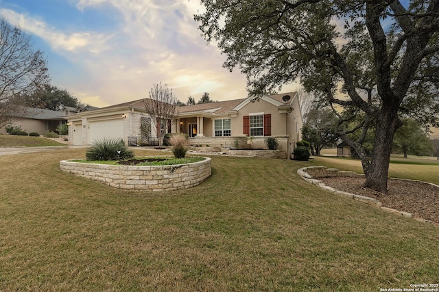 ranch-style house with a garage and a lawn