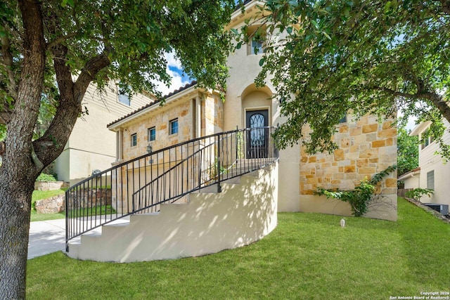 entrance to property with a yard and central AC