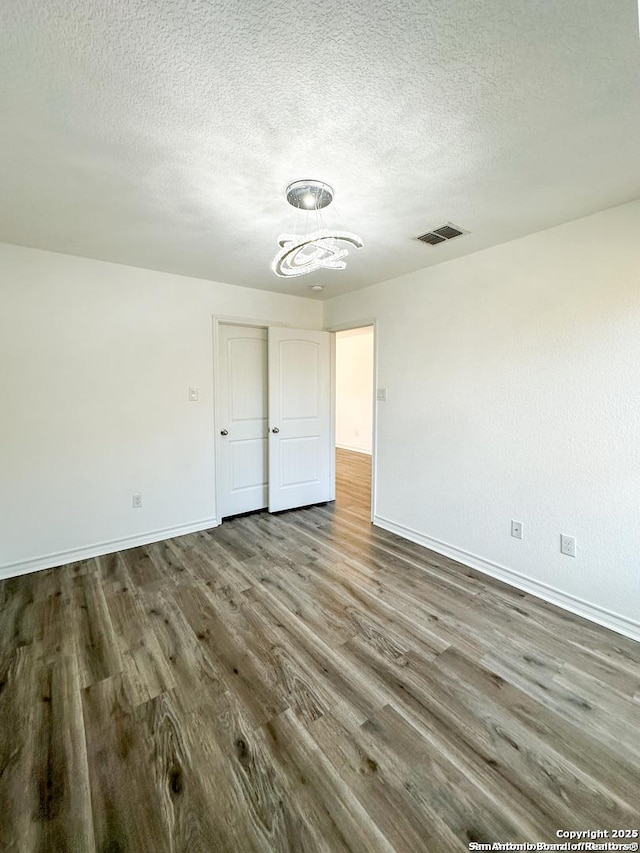 unfurnished bedroom with hardwood / wood-style floors and a textured ceiling