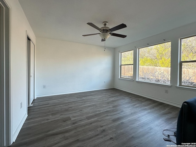 spare room with ceiling fan and dark wood-type flooring